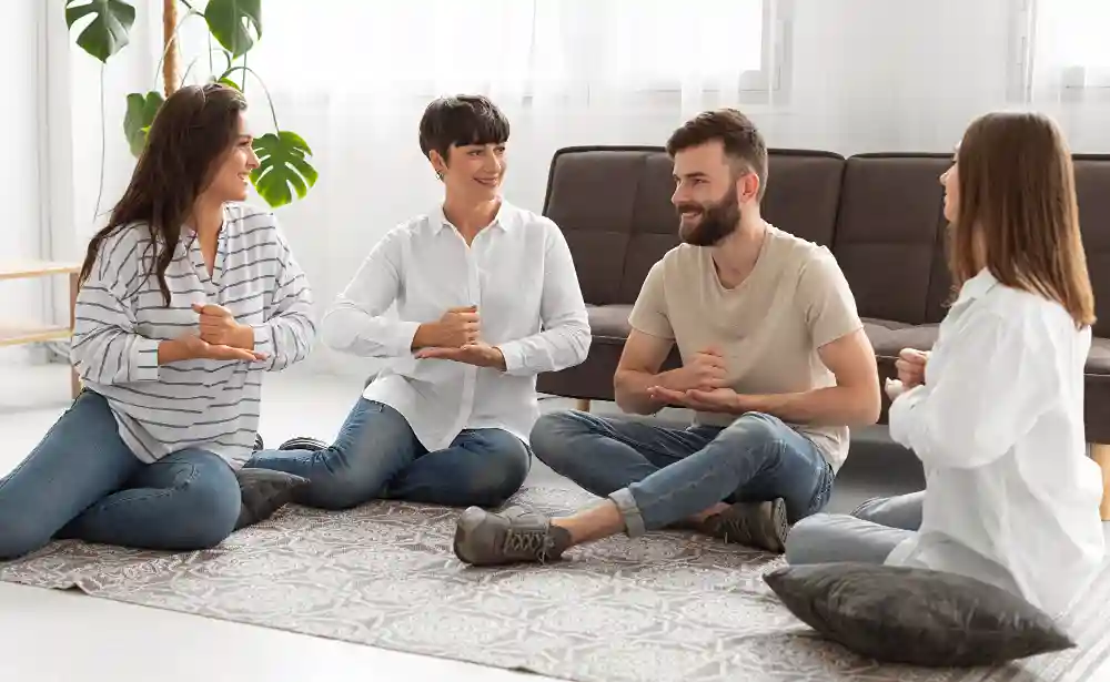 Four family members sit in a circle on the floor during a communication skills workshop