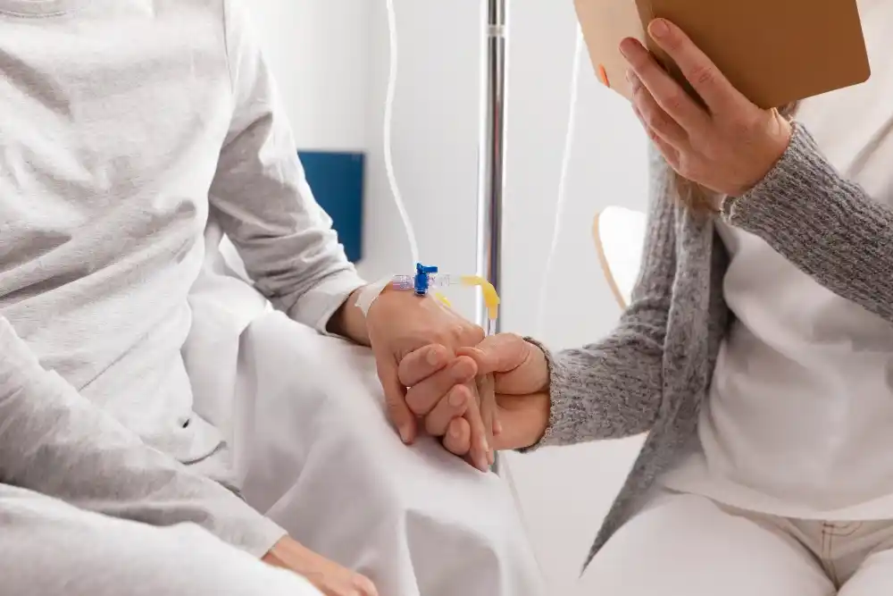 Nurse inserting IV needle into patient's arm during hydration therapy session