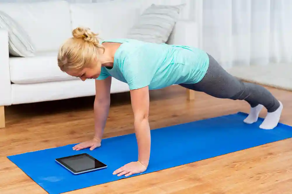 Woman doing plank exercise on yoga mat during home weight loss workout