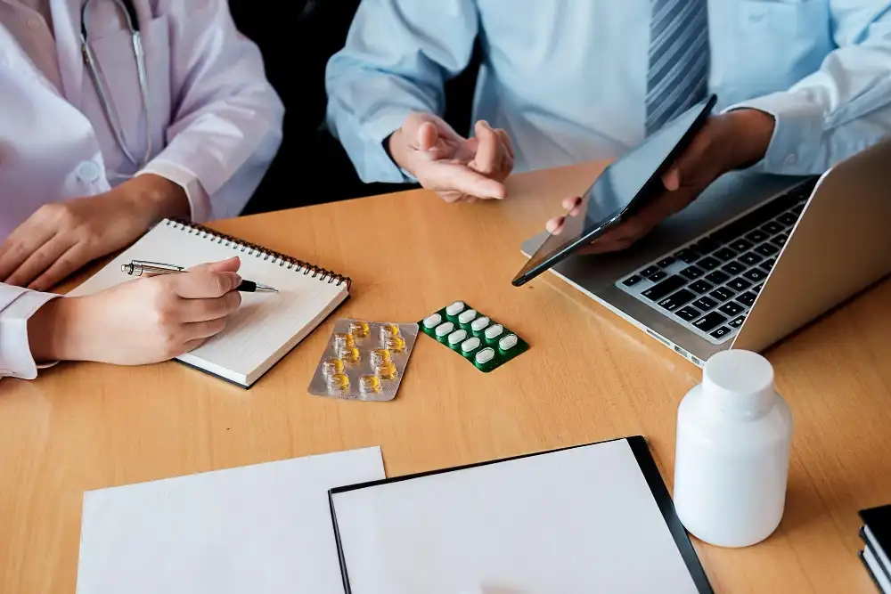 Mothermind medication management provider reviewing prescription options and clinical notes with a patient during a collaborative care session in Tampa FL